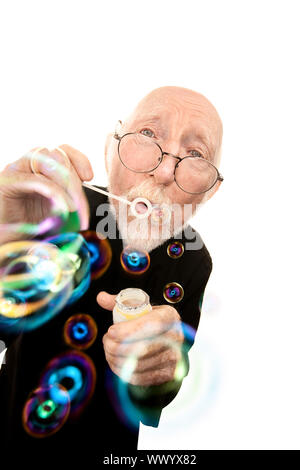 Lustige Priester in Robe mit Brille bläst Seifenblasen Stockfoto