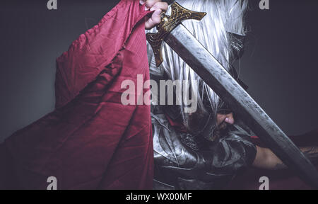 Roman Gladiator, Wrestler und Krieger von Rom mit Helm und roten Mantel, trägt ein Schwert, Bart und lange Haare. Stockfoto