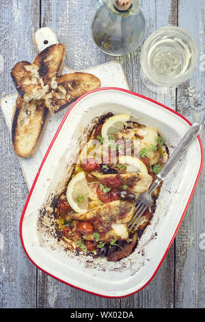 Gebratene John Dory Fischfilet mit Gemüse und Baguette als Top-Ansicht in einem Bräter Stockfoto