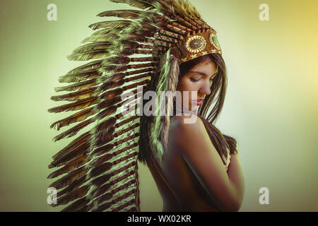 Ethnische Schöne junge Brünette mit großen Indianische Feder der braunen Federn. hat lange schwarze Haare Stockfoto