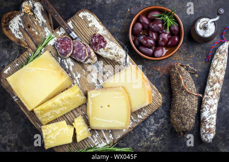 Traditionelle französische Wurst mit Käse und Salami als Draufsicht auf altem Schneidebrett Stockfoto