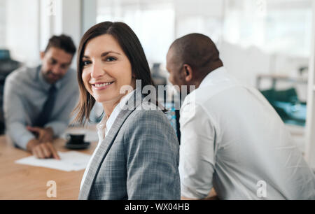 Lächeln, Geschäftsfrau, sitzen in einem Büro Meeting mit Kollegen Stockfoto