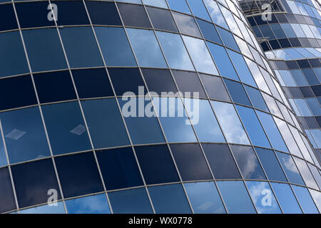 Die moderne Fassade des Business Center oder Gebäude mit Glasfenstern mit blauem Himmel Reflexion mit verschiedenen Schattierungen. Stockfoto