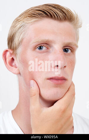 junger Mann mit blauen Augen denken über etwas auf mit Hintergrund Stockfoto