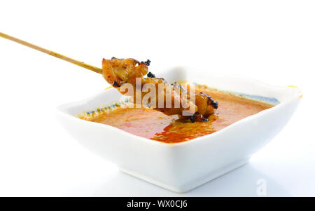 Köstliche Satay Chicken und Erdnuss-Sauce auf weißem Hintergrund Stockfoto