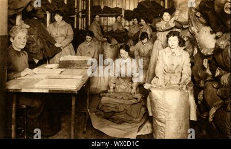 Sortierung Uniformen die Women's Army Auxiliary Corps Bekleidungsgeschäft, Erster Weltkrieg, 1914-1918, (1933). "Uniformen wurden an die WAAC Clothing stores, in denen Sie ausgepackt waren, gemessen, getestet, geprüft und neu verpackt, um die Rekrutierung der Zentrale gesendet werden. Von "Der Festzug des Jahrhunderts". [Odhams Press Ltd, 1933] Stockfoto