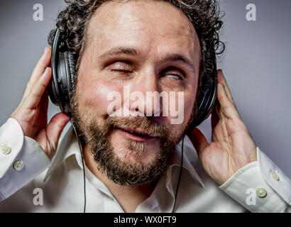 Genießen Sie die Musik, Mann mit intensiven Ausdruck, weißes Hemd Stockfoto