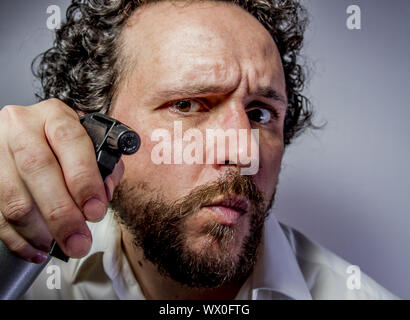 Reinigungsspray, Mann mit intensiven Ausdruck, weißes Hemd Stockfoto