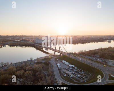 North Bridge mit einem großen Parkplatz für Autos über den Fluss Dnepr und einen Blick auf den Skaimol Shopping Center im Bereich Obolon Stockfoto