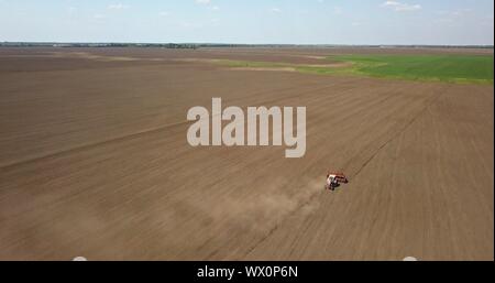 Traktor pflegt das Feld, Feder arbeitet auf Ackerland. Foto von der Drohne Stockfoto