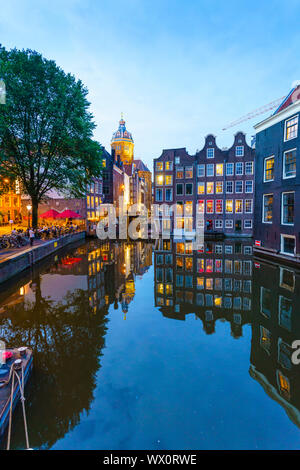 Alte giebelhäuser Gebäude, die durch einen Kanal in der Dämmerung, Oudezijds Kolk, Amsterdam, Nordholland, Niederlande, Europa Stockfoto