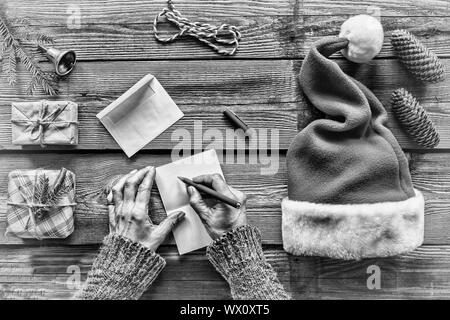 Schwarz und Weiß. Konzeption: Weihnachten. Die Weihnachtsgeschenke. Mann, schreibt einen Brief, Grußkarten Stockfoto