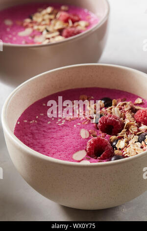 Frühstück smoothie Schüssel mit Müsli, Eis Beeren und auf Stein Hintergrund Mandel Stockfoto