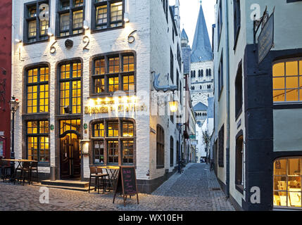 Salzgasse mit Restaurant, Blick durch die Gasse zu Groß Sankt Martin, Köln, Deutschland Stockfoto