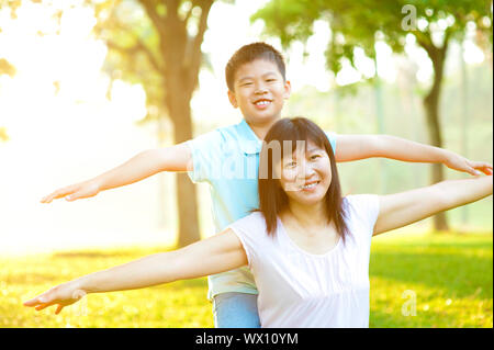 Asiatische Mutter und Kind glücklich spielen auf tropischen park Stockfoto