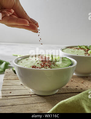 Mit frisch zubereiteten Gemüse Smoothies mit Avocado, Kiwi, Gurke und Müsli auf einer Platine für die Küche aus Holz Stockfoto