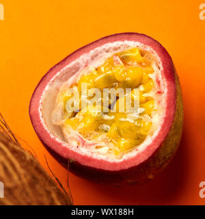 Passionsfrucht. Halbe Frucht isoliert auf Orange, Nahaufnahme Stockfoto