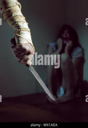 Angst vor Frau durch einen Mann mit blutigen Messer bedroht Stockfoto