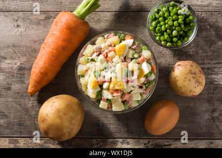 Die traditionellen russischen Salat und Zutaten für Weihnachten. Olivier Salat auf Holztisch. Ansicht von oben Stockfoto