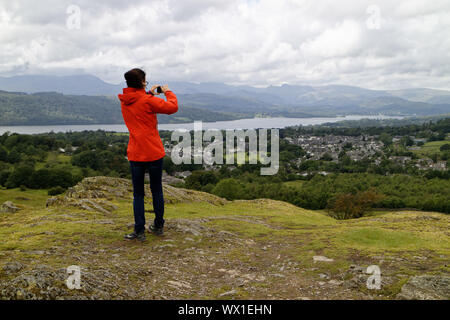 Eine Frau, die Fotos im Lake District mit Ihrem Mobiltelefon Stockfoto