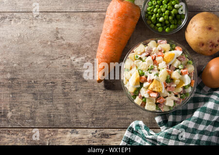 Die traditionellen russischen Salat und Zutaten für Weihnachten. Olivier Salat auf Holztisch. Ansicht von oben. Platz kopieren Stockfoto