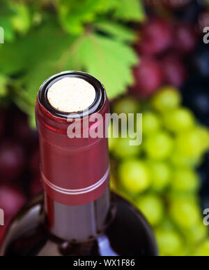 Bild von Wein Flasche mit Korken auf Trauben Hintergrund, Luxus alkoholischen Traubensaft trinken, selektiver Fokus verschiedener Rebsorten Arten, Restaurant oder im Freien Stockfoto