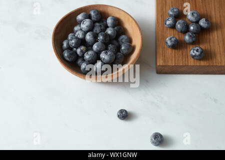 Sommer Organische natürliche Süße Blaubeeren in eine hölzerne Platte auf einem weißen. Kopieren Sie Platz. Stockfoto