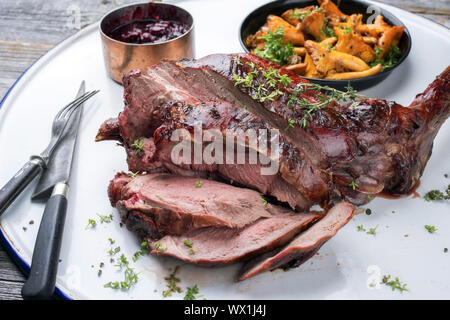 Marinierte geschnitten Grill alter Bein Rehrücken mit Pfifferlingen und kirschsauce als Draufsicht auf rustikalen Hintergrund Stockfoto