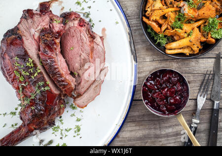 Marinierte geschnitten Grill alter Bein Rehrücken mit Pfifferlingen und kirschsauce als Draufsicht auf rustikalen Hintergrund Stockfoto