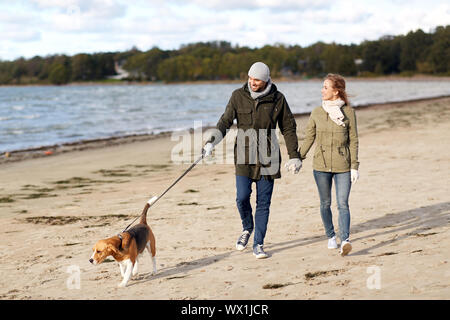 Paar mit Beagle Hund entlang Herbst Strand Stockfoto