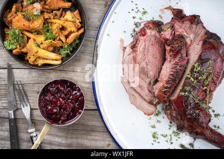 Marinierte geschnitten Grill alter Bein Rehrücken mit Pfifferlingen und kirschsauce als Draufsicht auf rustikalen Hintergrund Stockfoto