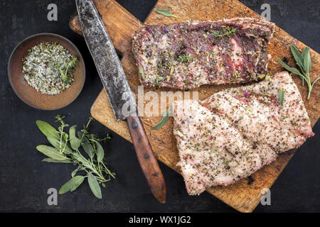 Ausgehärtete wild Schweinebauch mit Gewürzen wie Draufsicht auf einem alten Schneidebrett Stockfoto