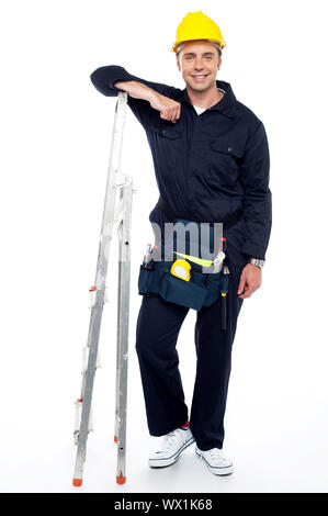 In voller Länge Portrait von Wirtschaftsingenieur ruht seine Hände auf Stehleiter Stockfoto