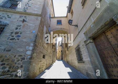 Mittelalterlichen Kopfsteinpflaster und trat Straße mit Blumen geschmückten Balkonen und öffentliche Beleuchtung Lampen in der Stadt Toledo. Spanien Stockfoto