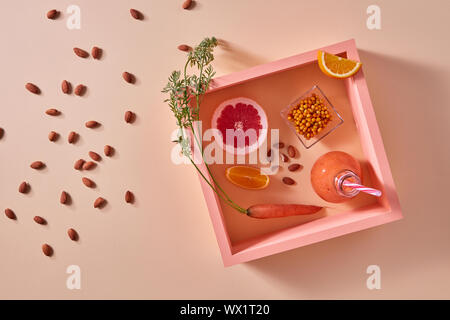 Bio Gemüse Smoothies mit Zitrusfrüchten, Mandeln und Sanddorn in einer Flasche auf gelbem Papier Hintergrund Stockfoto