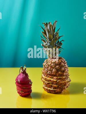 Tropische Ananas Obst Ganzes und Drachenfrucht pitaya, bis der sliceson auf einem Duplex gelb-grünen Hintergrund Stockfoto