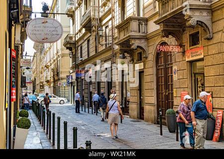 Menschen zu Fuß hinter einem paninni Shop entlang der Via Palazzo di Città, eine schmale Straße von der Piazza Castello, Turin, Italien Stockfoto