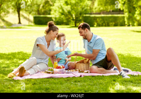 Glückliche Familie mit Picknick im Sommer Park Stockfoto