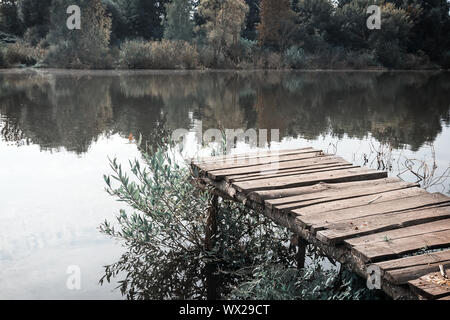 Alte ruiniert Pier auf dem Fluss an einem nebligen Morgen. Stockfoto