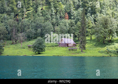 Konigssee in der Nähe von Berchtesgaden mit Wald und kleinen Schuppen umgeben, Deutschland Stockfoto