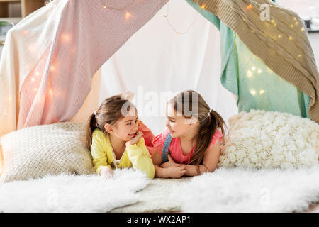 Glückliche Mädchen in Kinder Zelt liegen und sprechen zu Hause Stockfoto