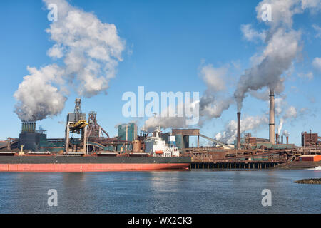 Großes Schiff vor einem großen Stahlwerk in IJmuiden, Netherla Stockfoto