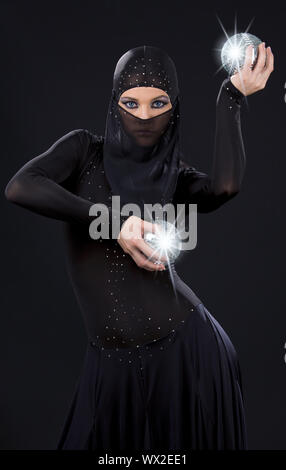 Partei-Tänzerin in Ninja-Kleid mit Disco-Kugeln Stockfoto