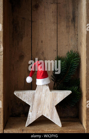 Weihnachtsdekoration Weihnachtsmann Hut auf einem Stern in einer Holzkiste Hintergrund Stockfoto