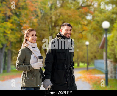 Paar mit Zuhaltung entlang Herbst Park Stockfoto