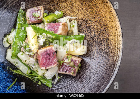 Moderne gebratener Thunfisch tataki Rinderfilet Salat mit weißen Spargel Zucker Snaps und Parmesan als Draufsicht auf einer Platte Stockfoto