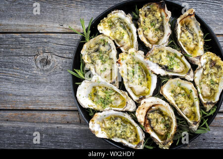 Grill overbaked frische Austern mit Knoblauch und Kräuter als Draufsicht auf einem Tablett mit Kopie Raum angeboten geöffnet Links Stockfoto