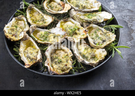 Grill overbaked frische Austern mit Knoblauch und Kräuter als Draufsicht auf einem Tablett Angeboten geöffnet Stockfoto