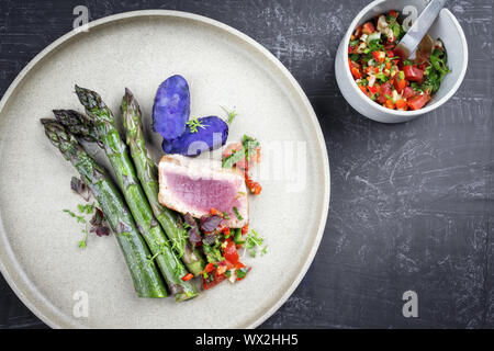 Moderne gebratener Thunfisch Filet mit grünem Spargel blaue Kartoffeln und Gemüse chili genießen, wie es oben auf einer Platte mit Kopie spac Stockfoto