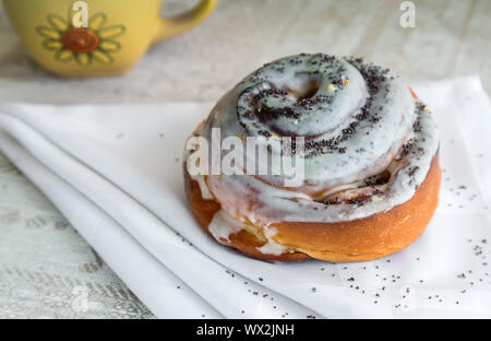 Lecker Brötchen mit der Glasur und Mohn. Stockfoto